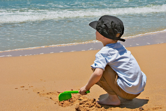 Young boy playing in sand at the beach